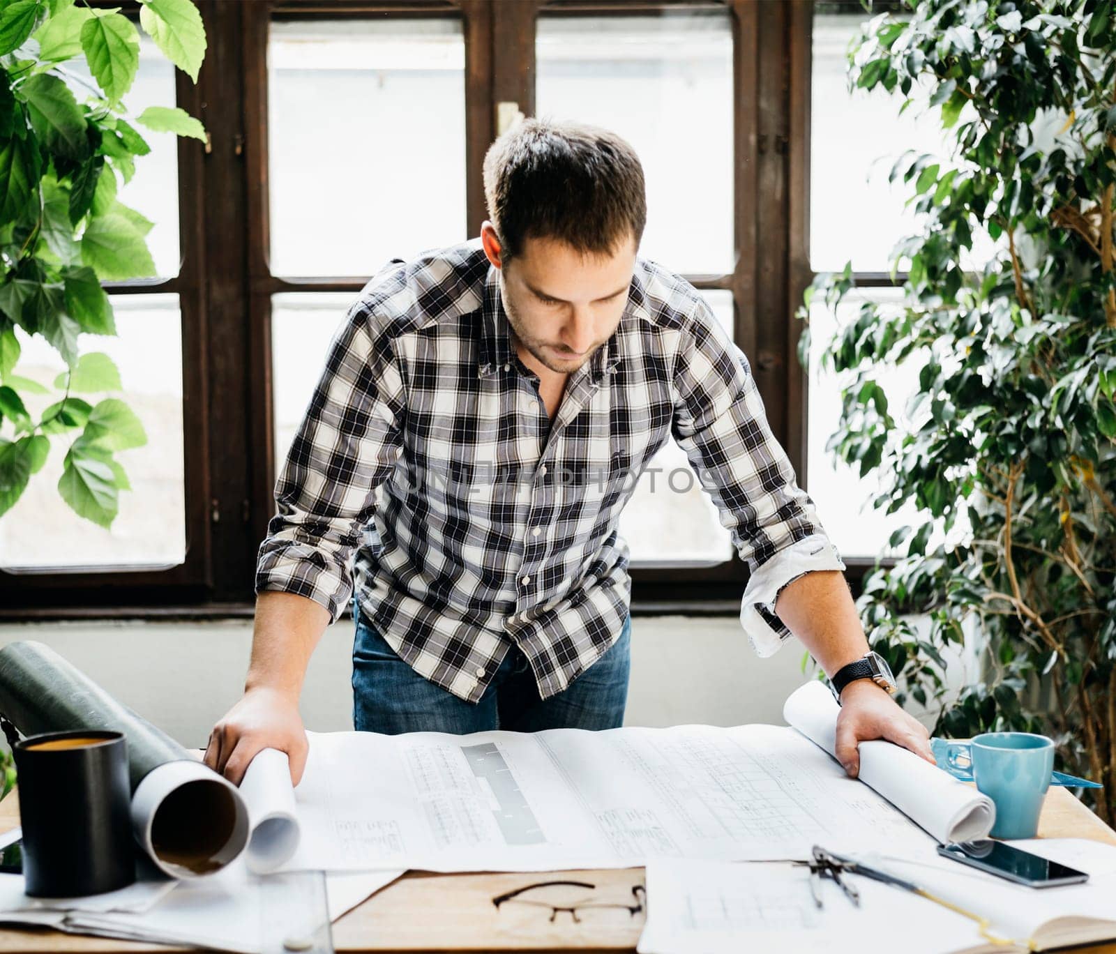 Young man working on architectural project. Modern office concept.