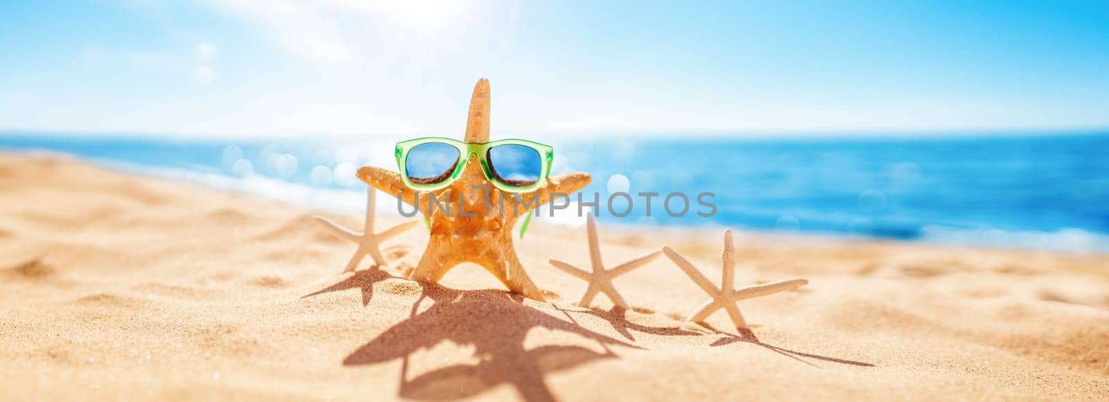 Starfishes on the beach sand in summer. Concept of tourism and vacation.