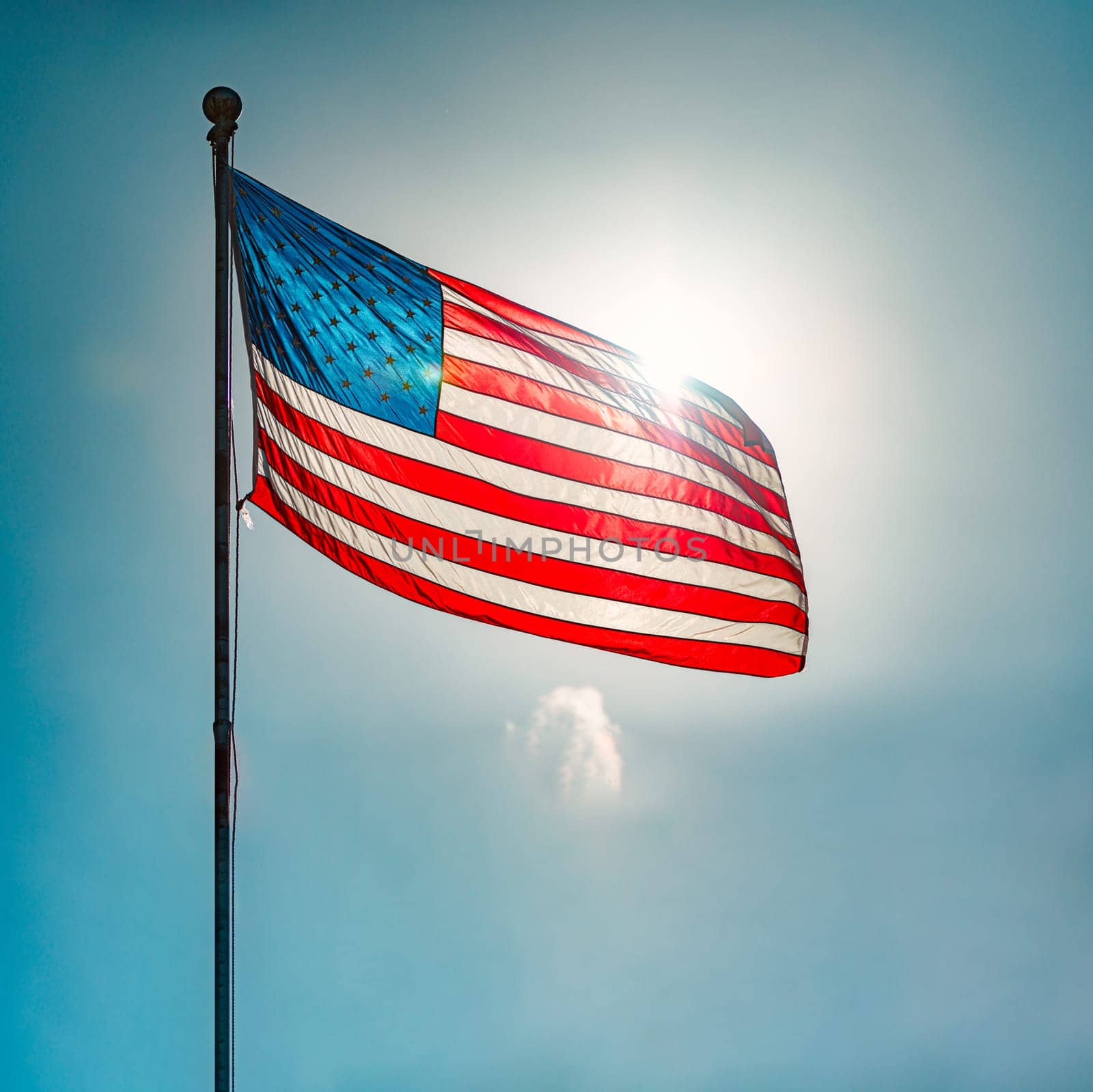 US american flag and blue cloudy sky with clouds in background