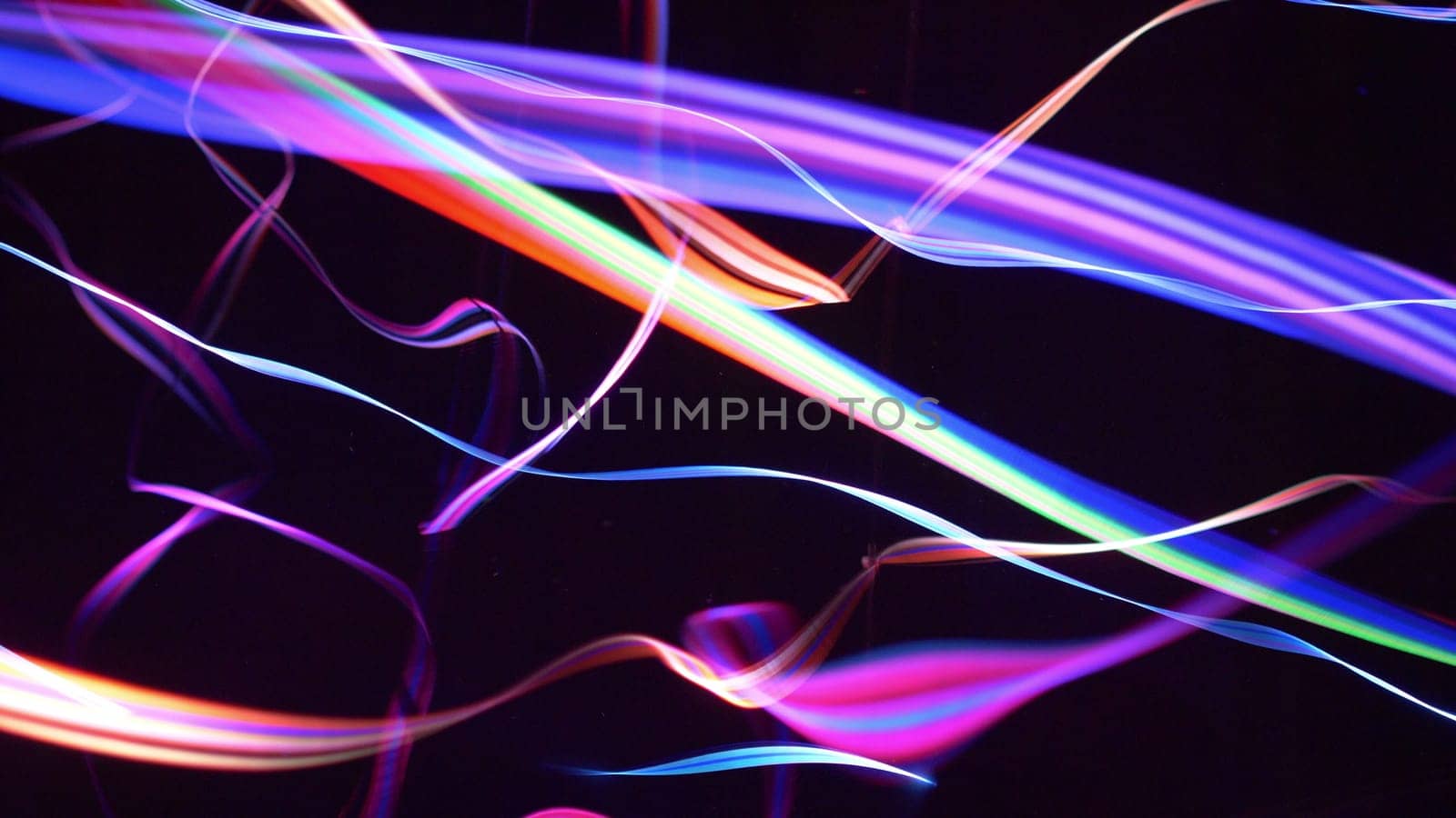 Colorful fiber strings in motion against black background