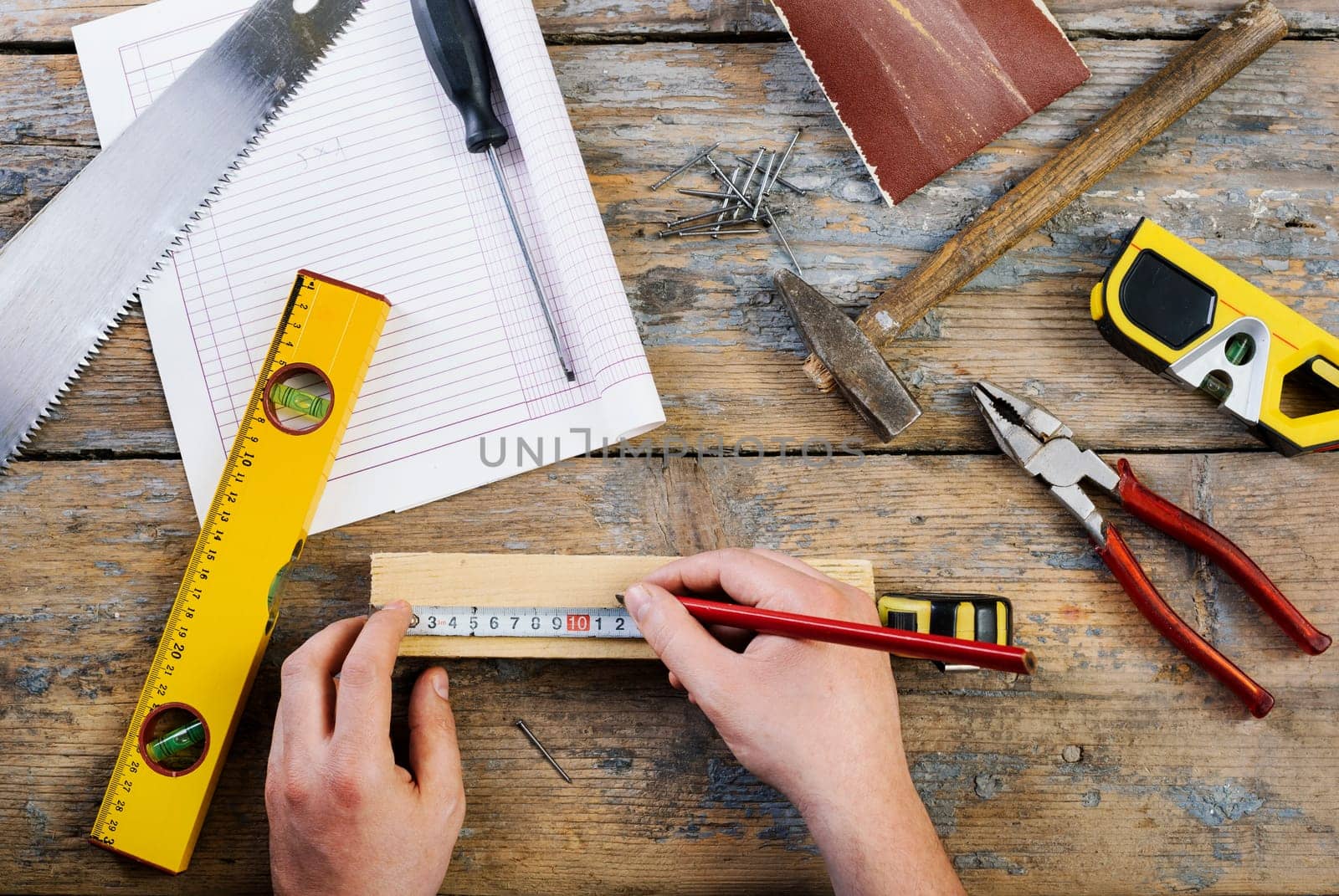 Male hands working on carpenter's desk and working tools.