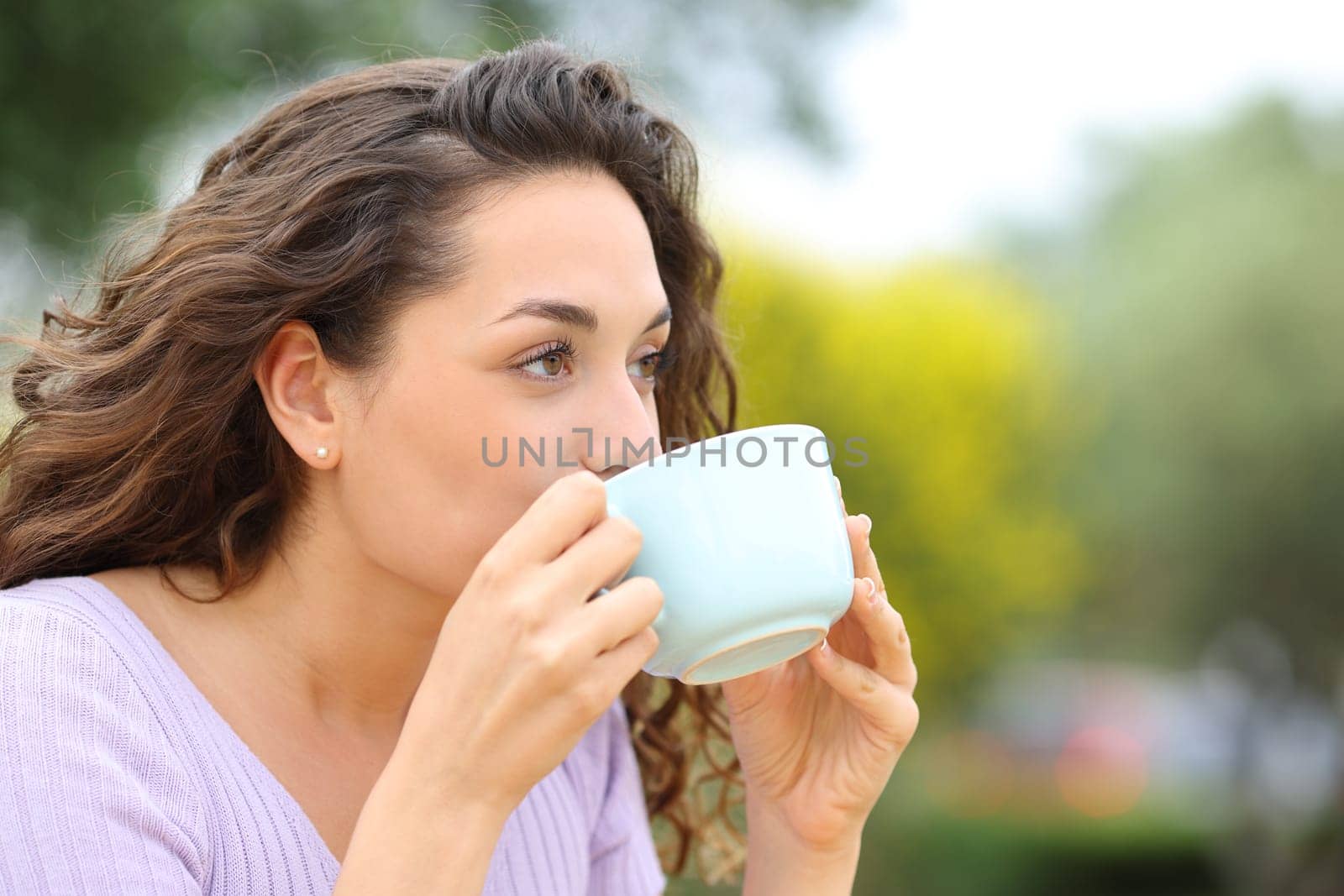 Beautiful woman relaxing drinking coffee in a park