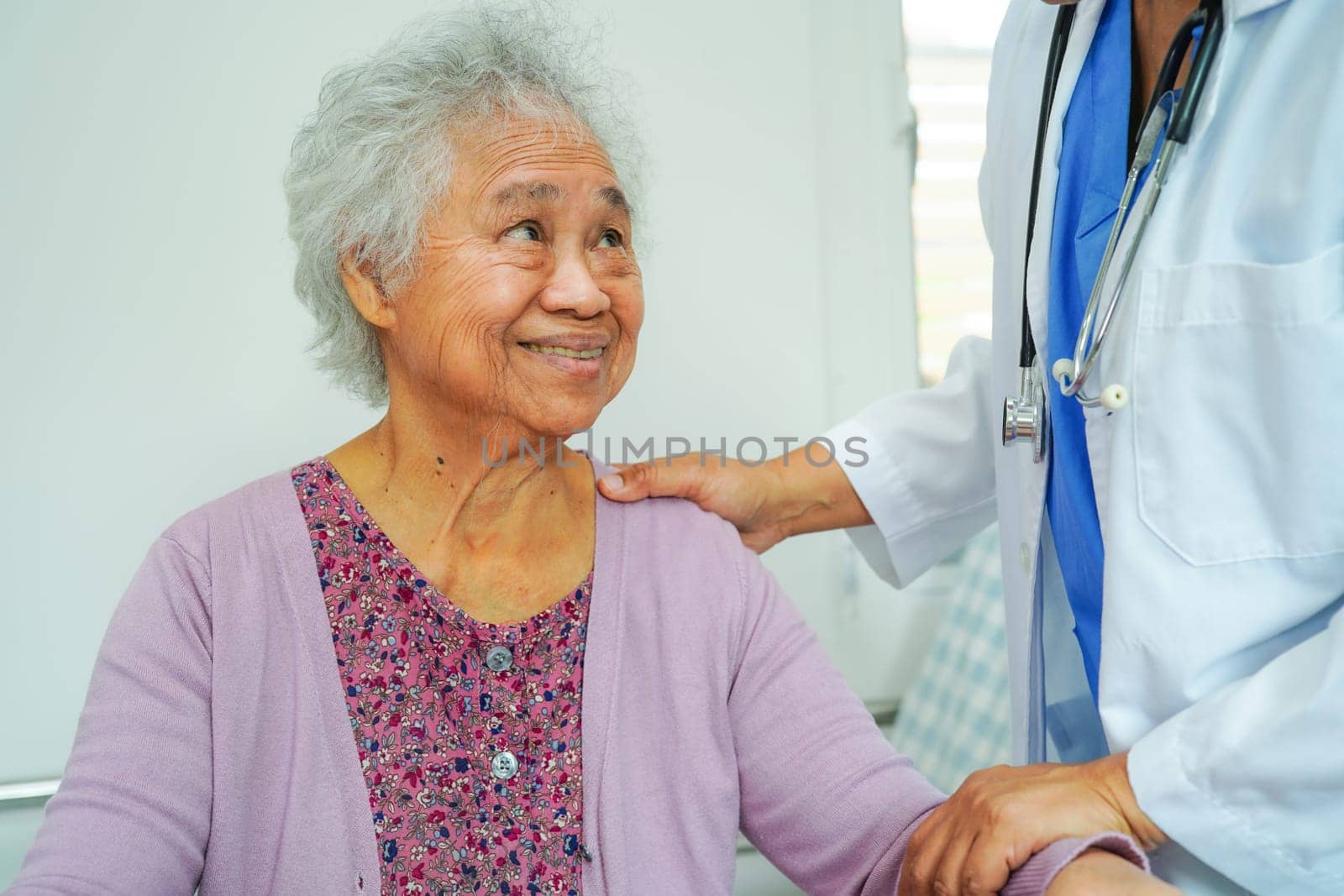 Doctor help Asian elderly woman disability patient walk with walker in nursing hospital, medical concept.