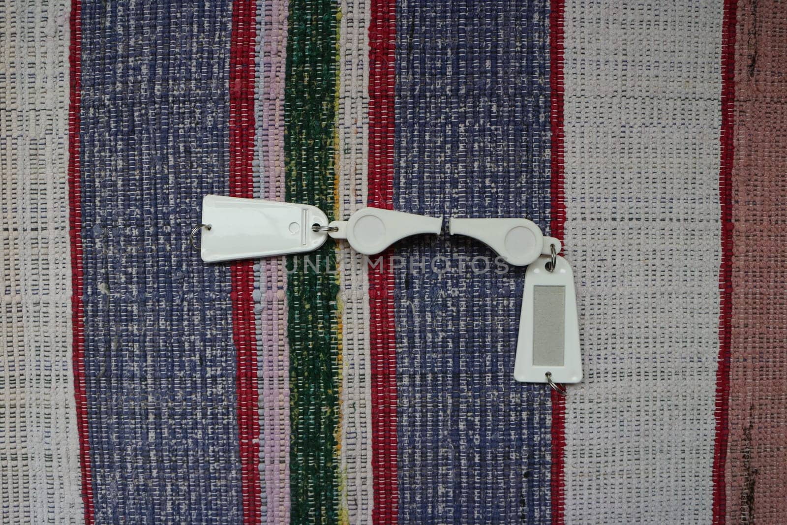 two white sports whistle, signal, fan, with a tag still life