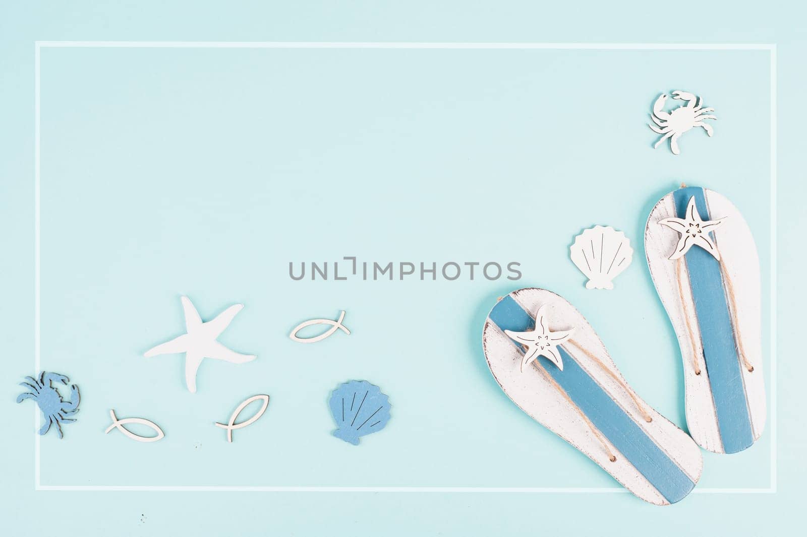 Blue colored summer and holiday background, flip flops, sea stars and crabs with copy space, travel and tourism concept
