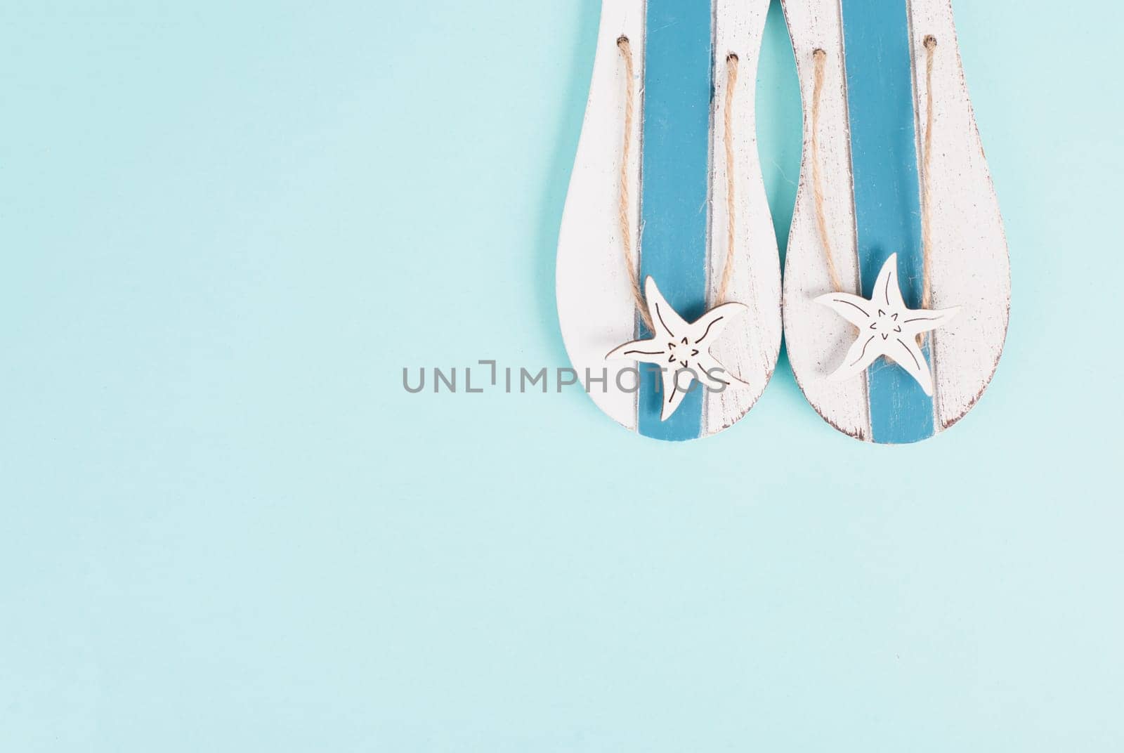 Blue colored summer and vacation background, slippers with sea stars, copy space for text, holiday and tourism concept