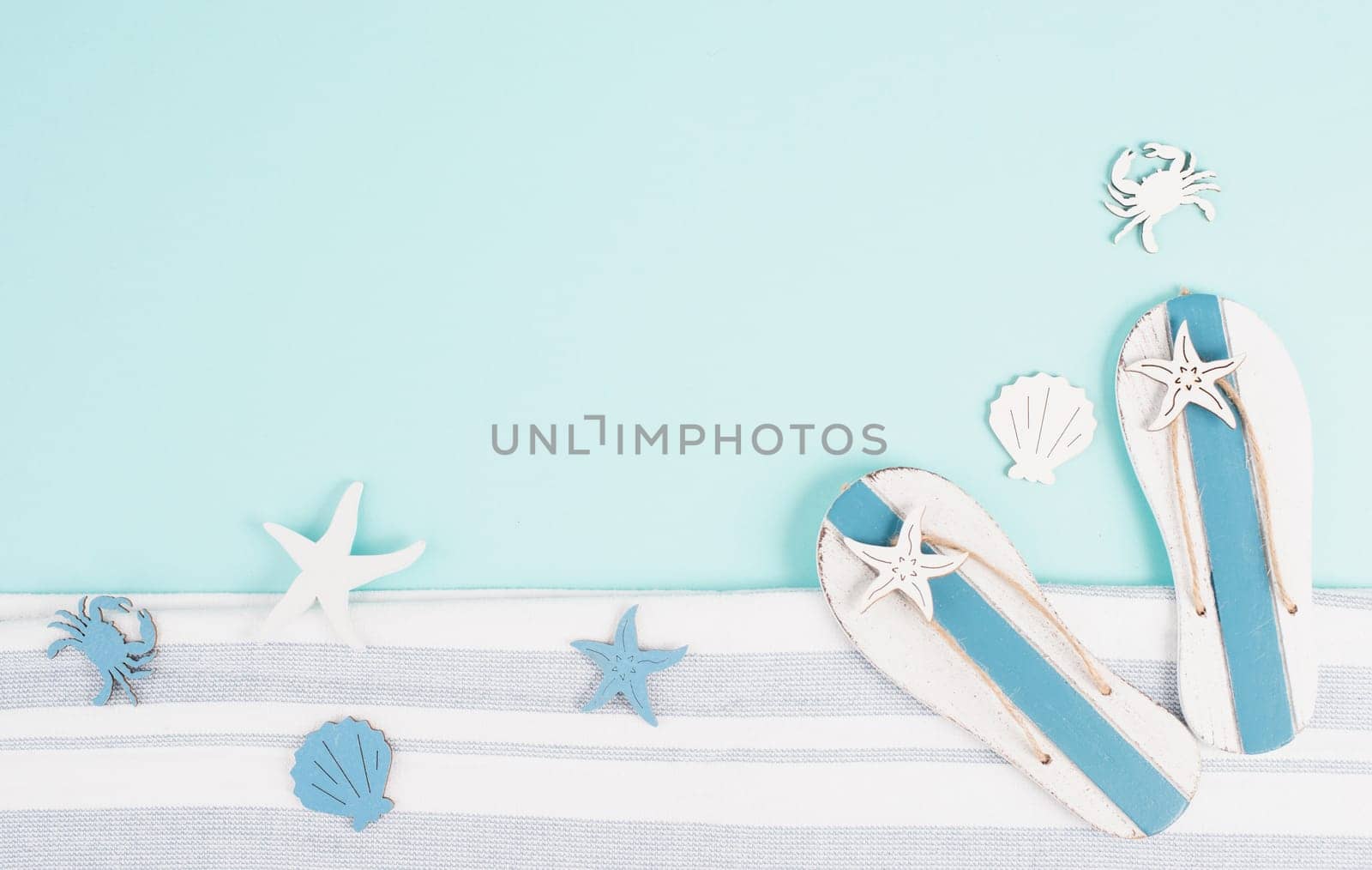 Blue colored summer and holiday background, flip flops, sea stars and crabs with copy space, travel and tourism concept