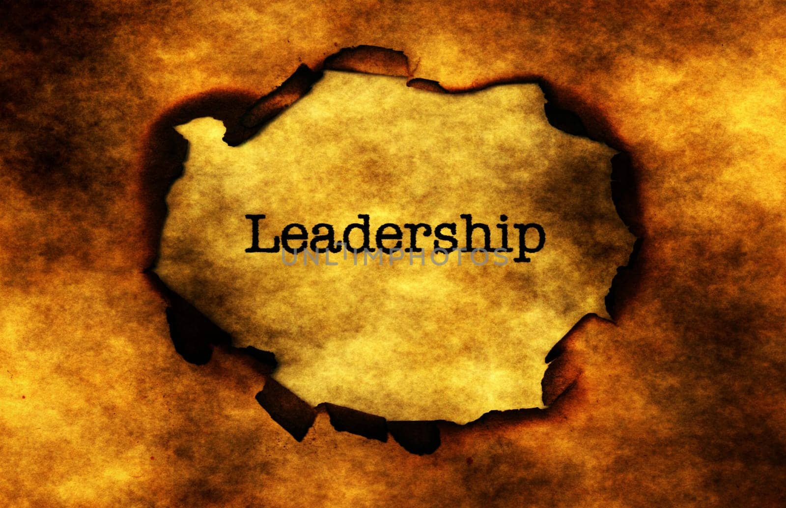 Leadership text on burning paper hole