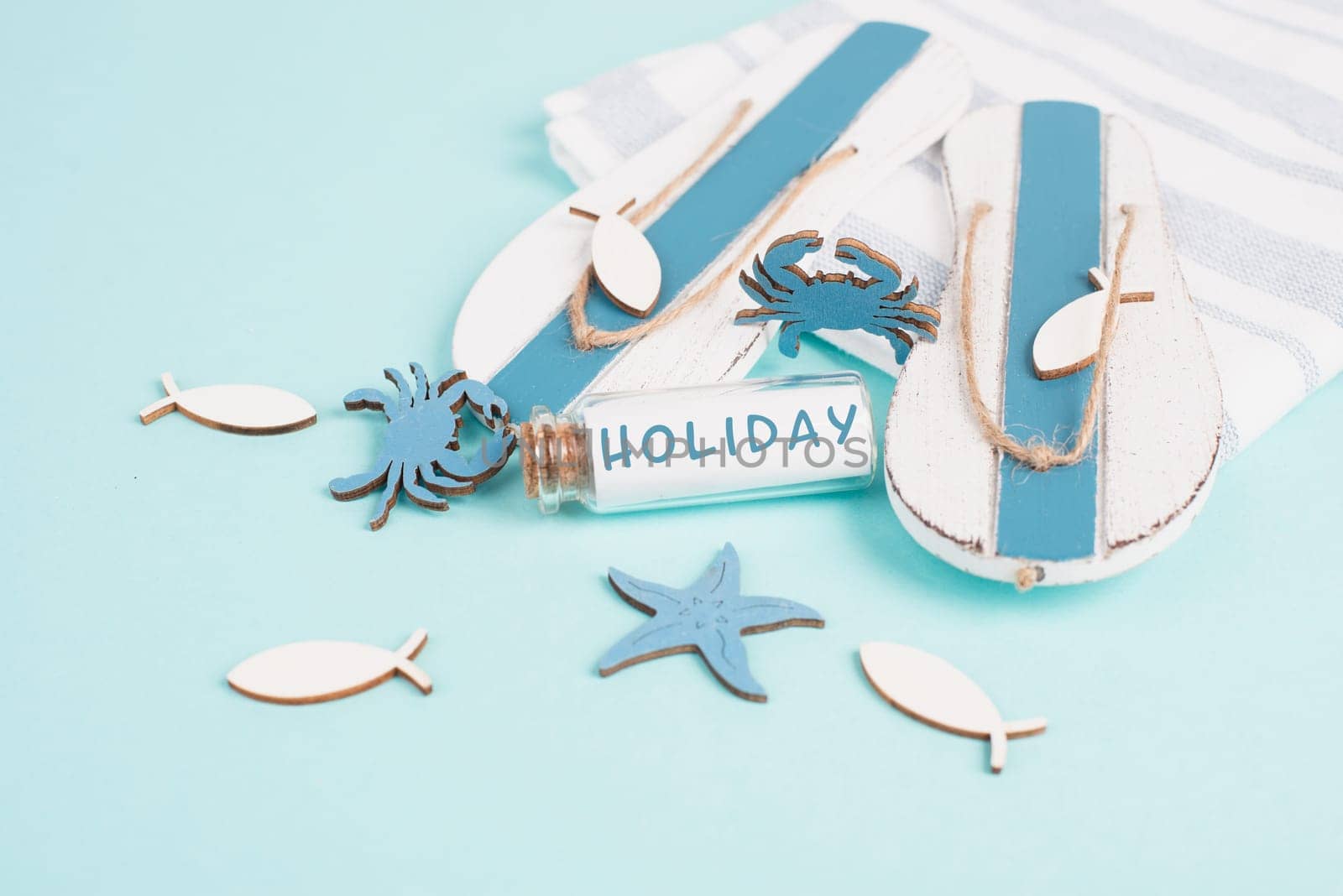 Blue colored summer and vacation background, flippers, sea stars and a glass bootle with the word holiday, travel and tourism concept