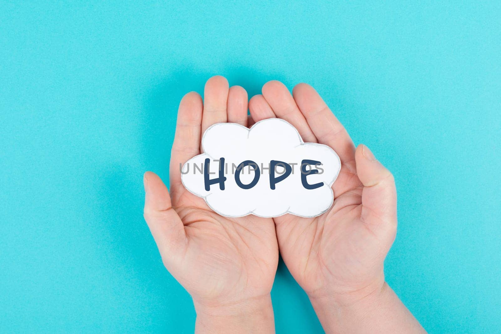 Holding a cloud with the word hope in the palm of the hands, trust and believe concept, having faith in the future, hopeful positive mindset