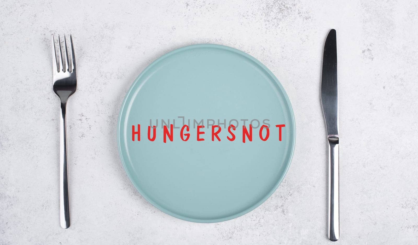 Famine is standing in german language on the plate, food shortage and starving because of the war and inflation, political issue