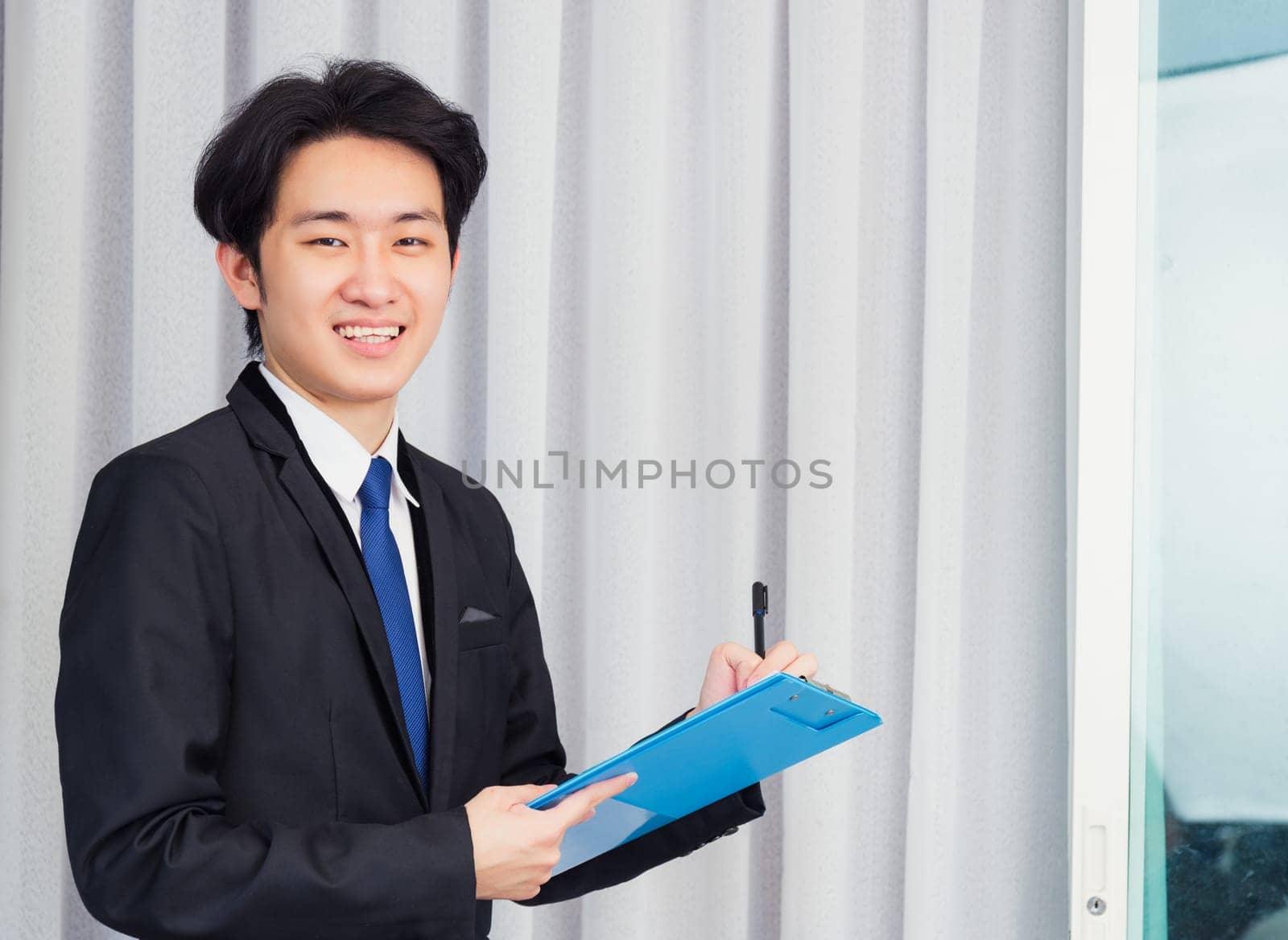 Work from home, Asian young businessman video conference call or facetime he smiling write notebook information at the home office