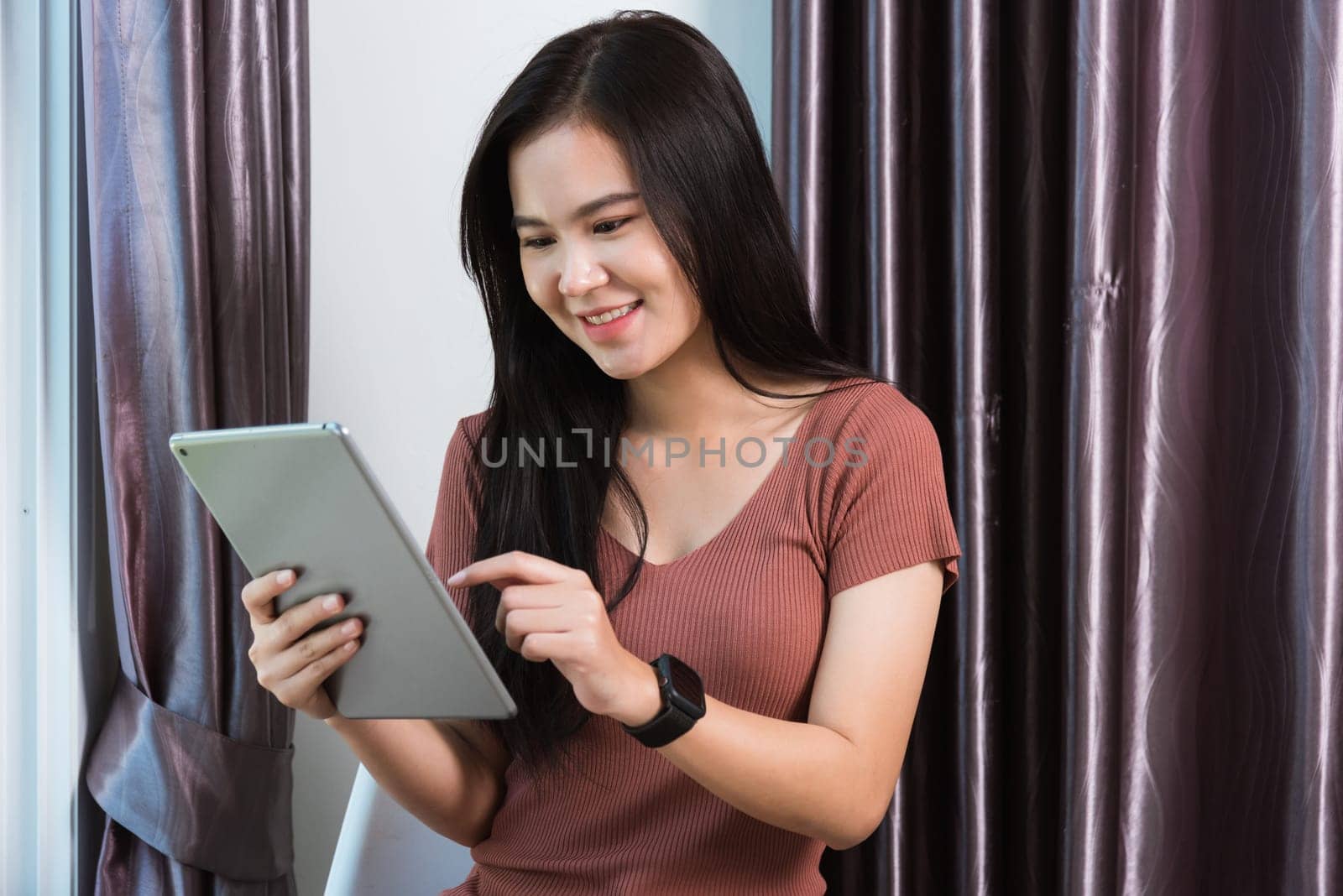 Work from home, Happy Asian young businesswoman smile video conference call or facetime by modern digital smart tablet computer she uses finger touching on screen, looking to tablet at home office