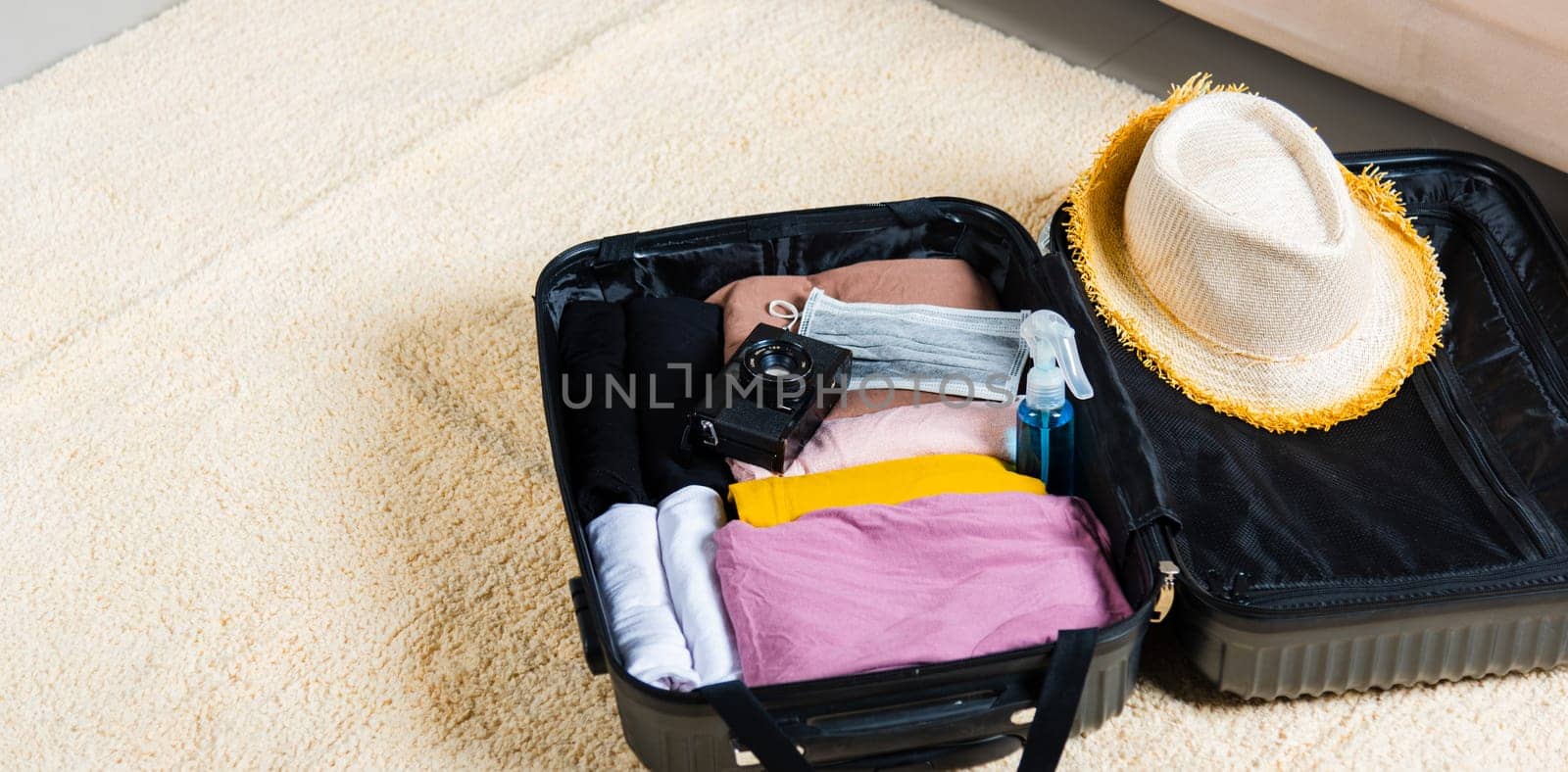 Open suitcase with traveler belongings clothes and accessories of things ready packing to be taken on summer holiday, Travel vacation luggage preparations concept, top view