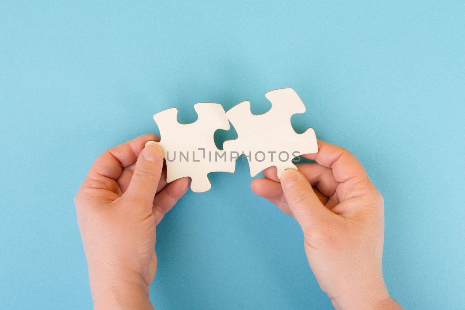 Holding two pieces of a puzzle in the hands, connecting together as a team, solving a problem, strategy and communication concept
