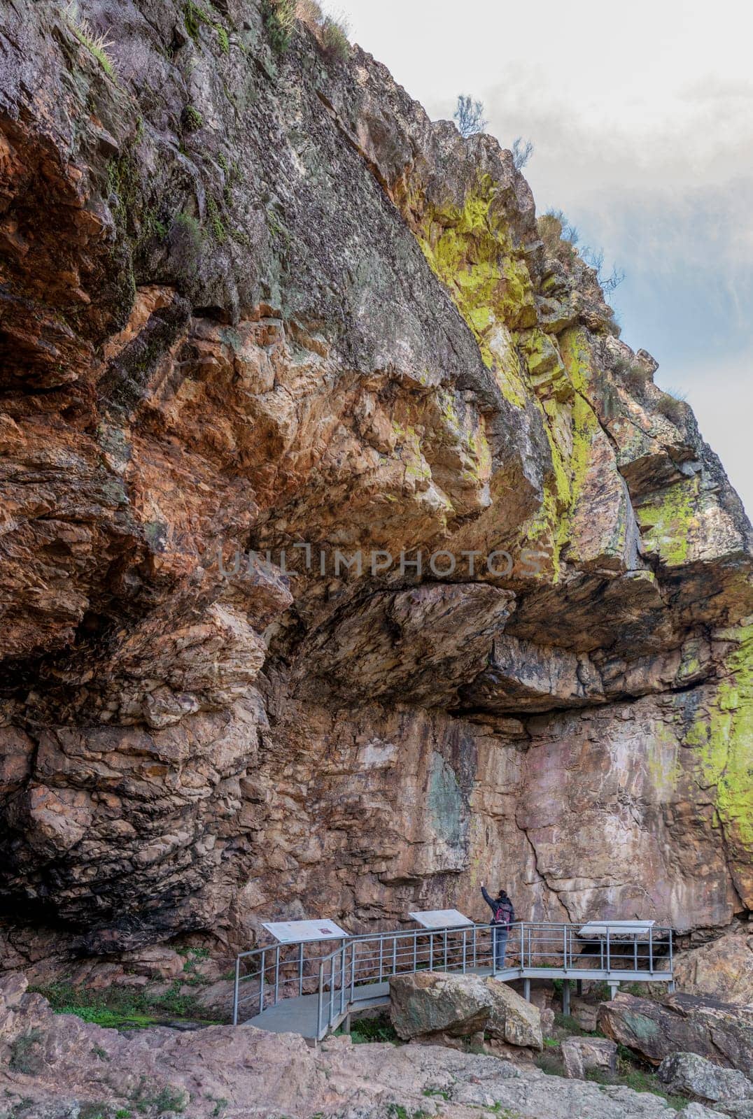 Visitor at Chiquita Cave, rock shelter with prehistorical paintings at Villuercas geopark. Canamero, Caceres, Extremadura, Spain