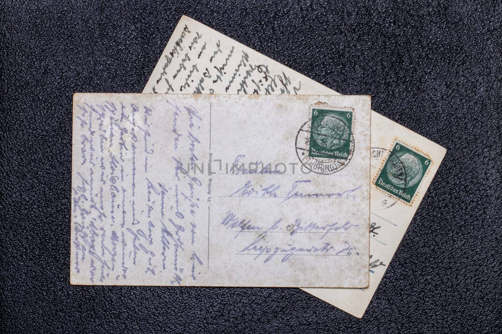 Potsdam, Germany - MAY 06, 2022. Old postcards from 1935 and 1939 with stamps showing the portrait of the German Reich President Paul von Hindenburg, Germany, Third Reich. Black background.