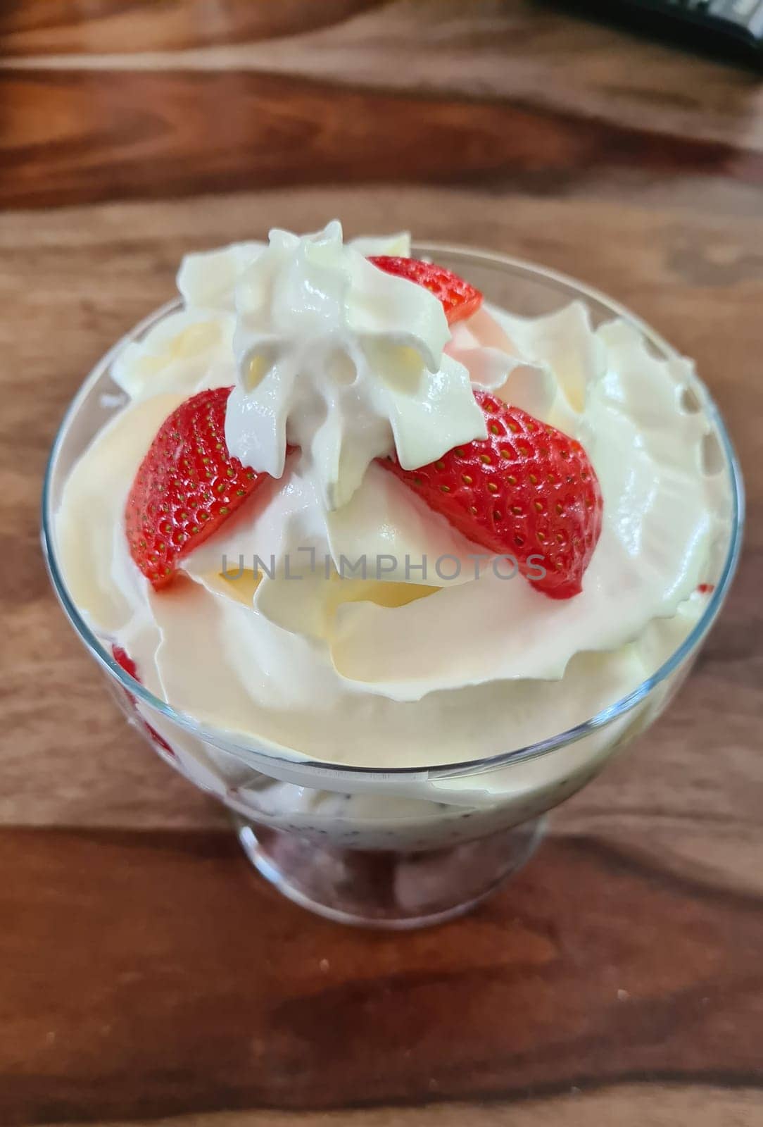 Homemade strawberry ice cream made from fresh berries with basil in glass bowl on gray background. soft focus.