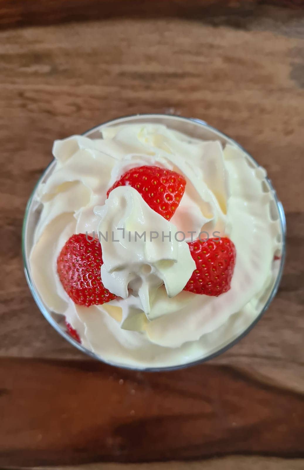 Homemade strawberry ice cream made from fresh berries with basil in glass bowl on gray background. soft focus.