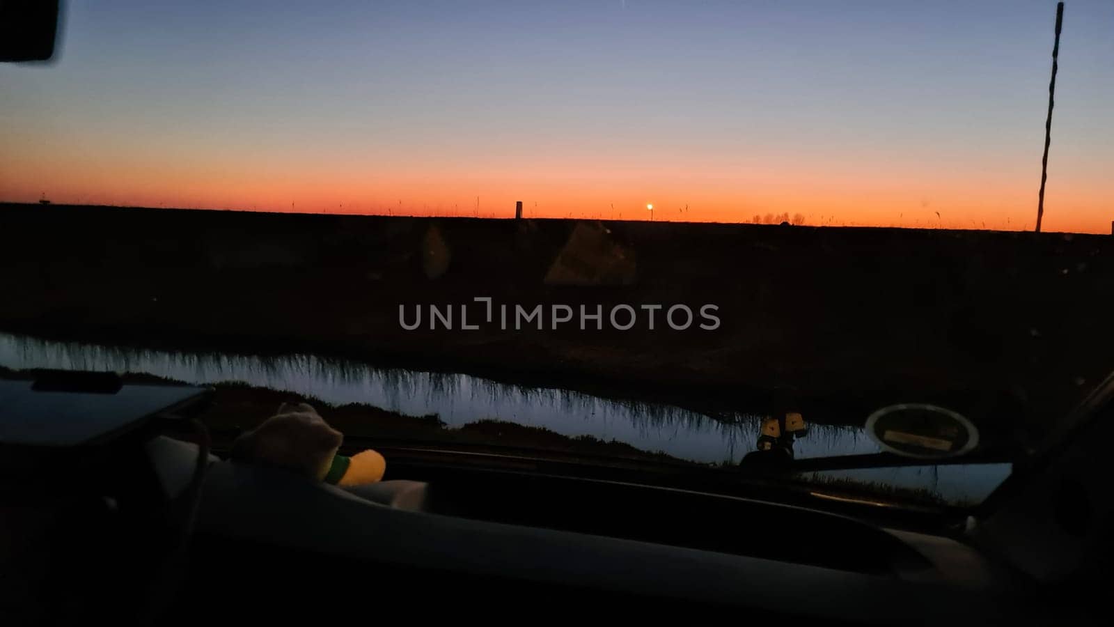 Camper van in the sunset in the background a Dutch windmill
