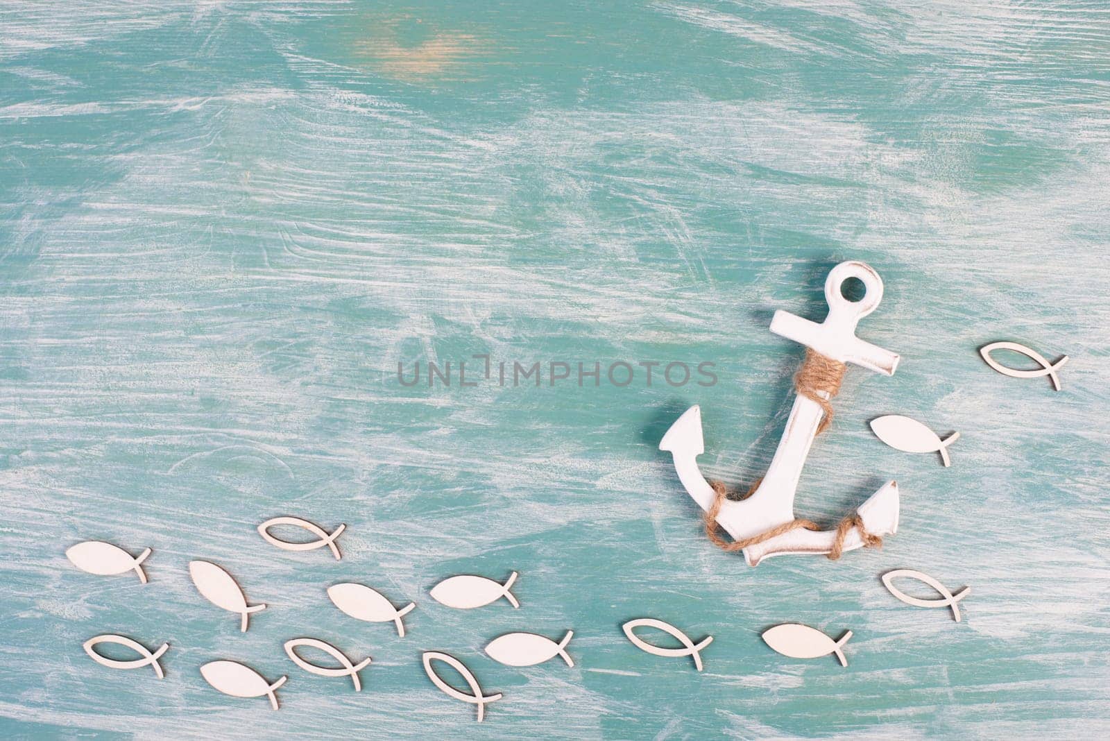 White anchor and fish on a blue background, maritime sea life, sailing trip, summer vacation, tourism concept, harbor