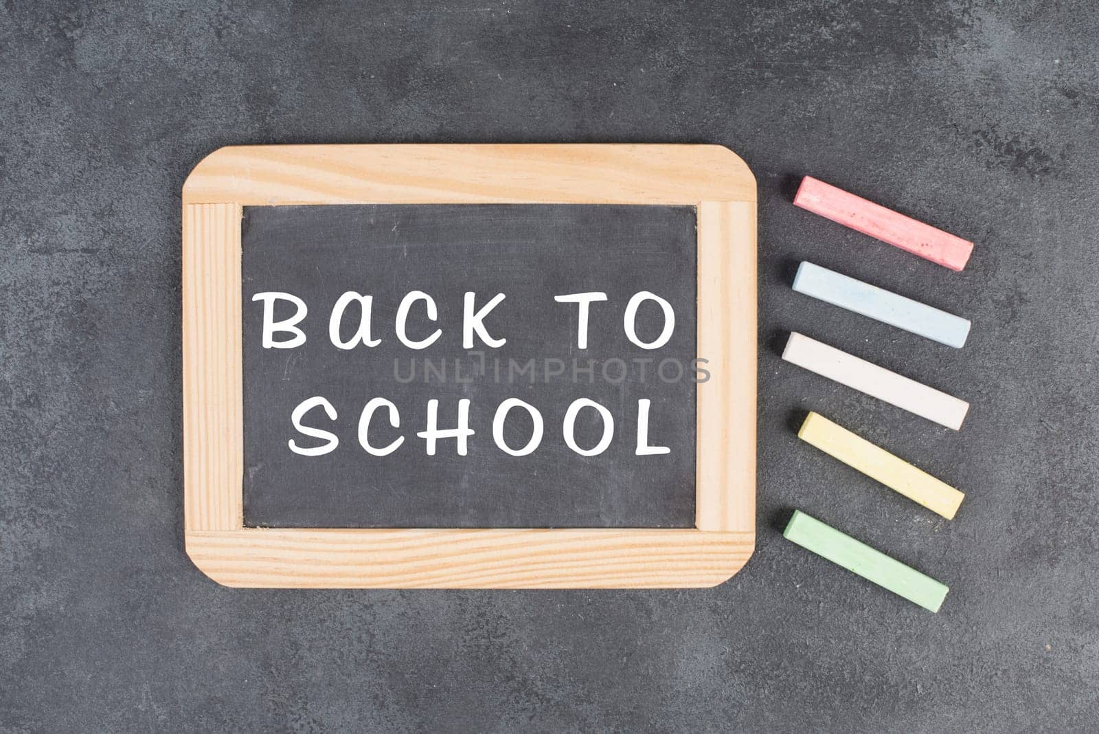 Chalkboard with the text back to school, education concept, colorful chalk