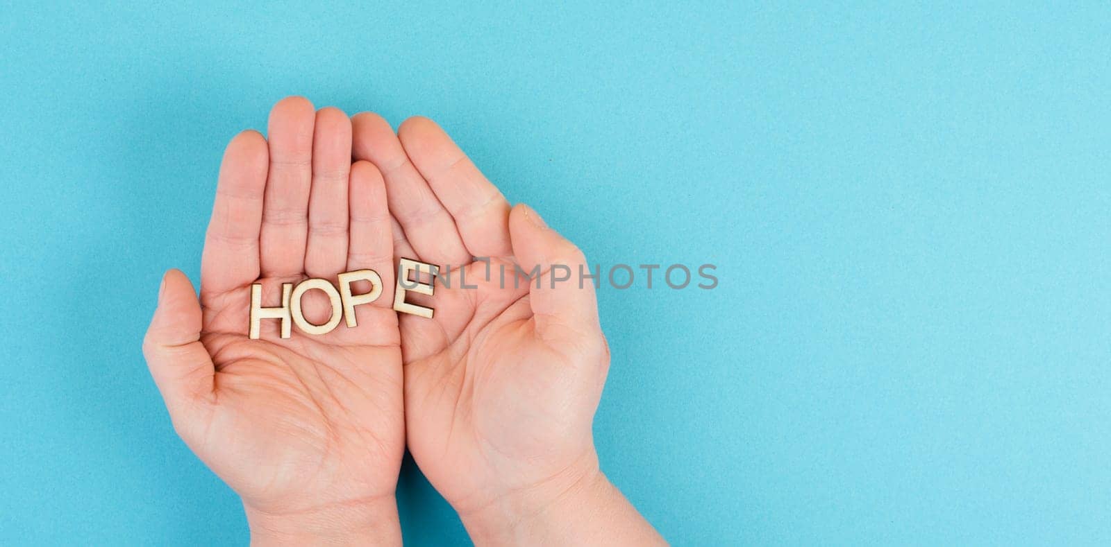 Holding the word hope in the palm of the hands, trust and believe concept, having faith in the future, hopeful positive mindset