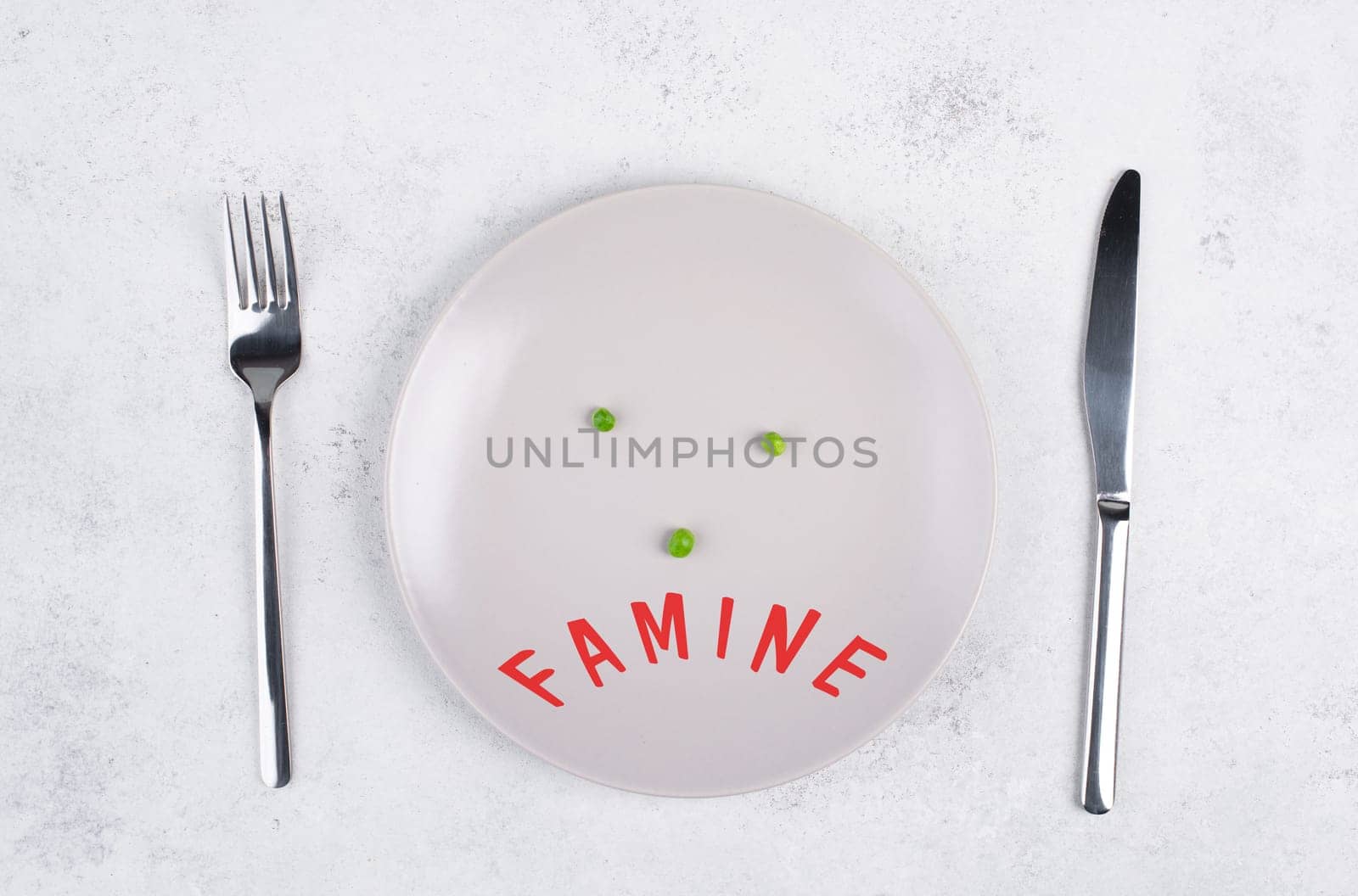Famine is standing in german language on the plate, food shortage and starving because of the war and inflation, political issue