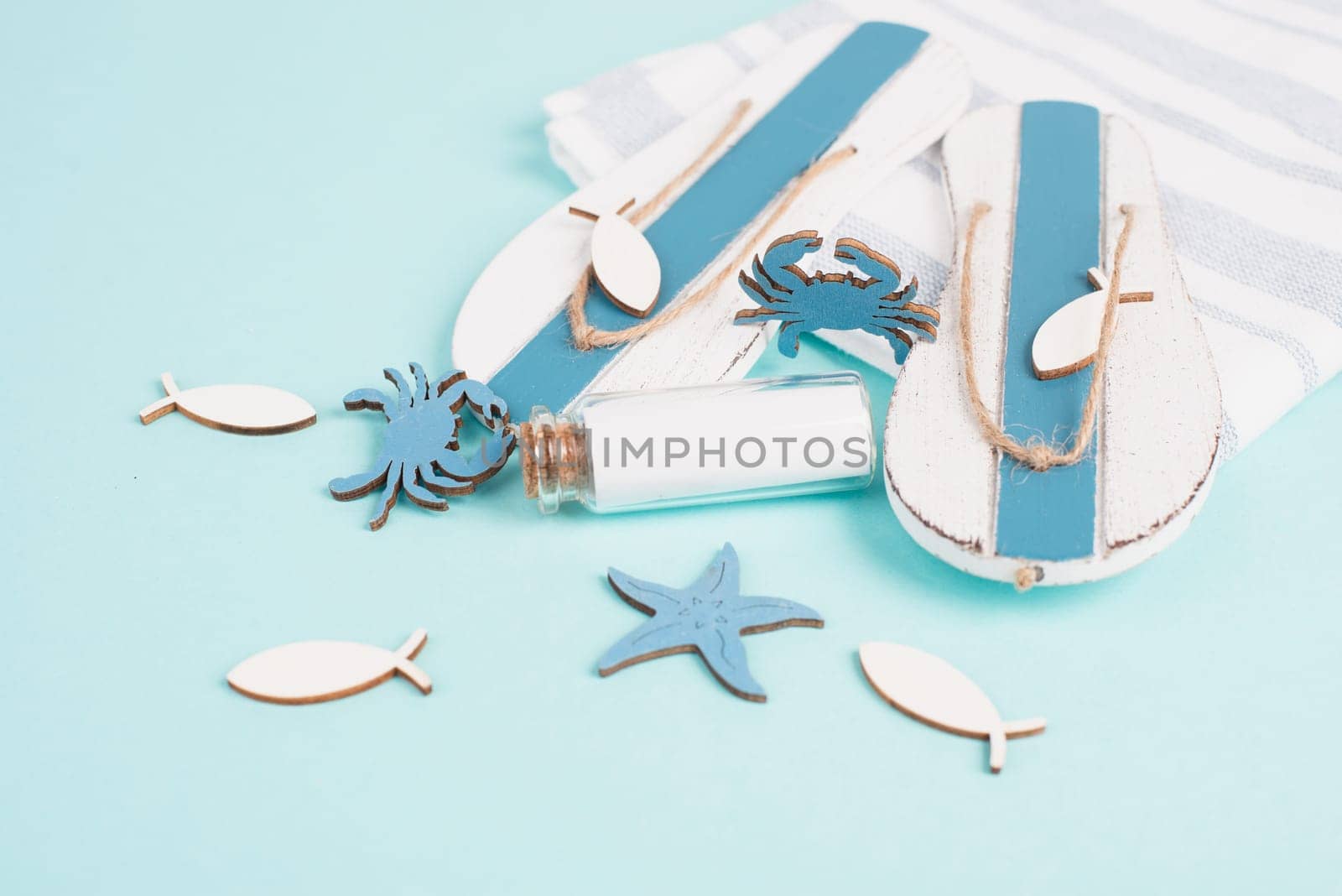 Blue colored summer and vacation background, flip flops, bottle and sea stars building a frame, copy space for text, holiday and tourism concept