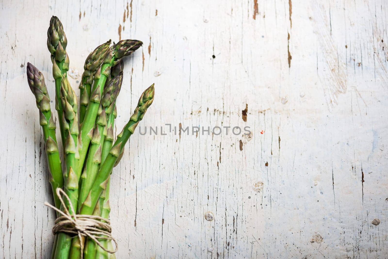 Fresh green asparagus on rustic white table
