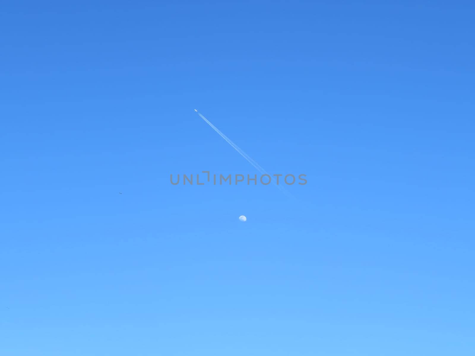 beautiful photo of the moon with plane crossing travel