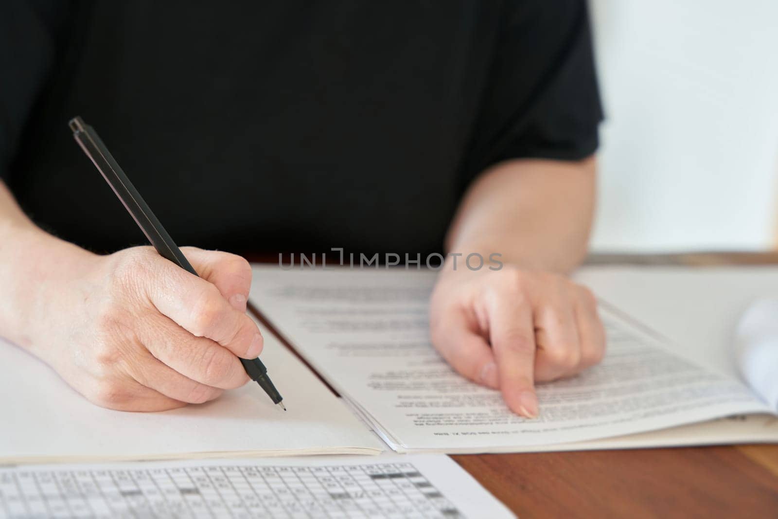 Close up of hand with pen writing at desk in office