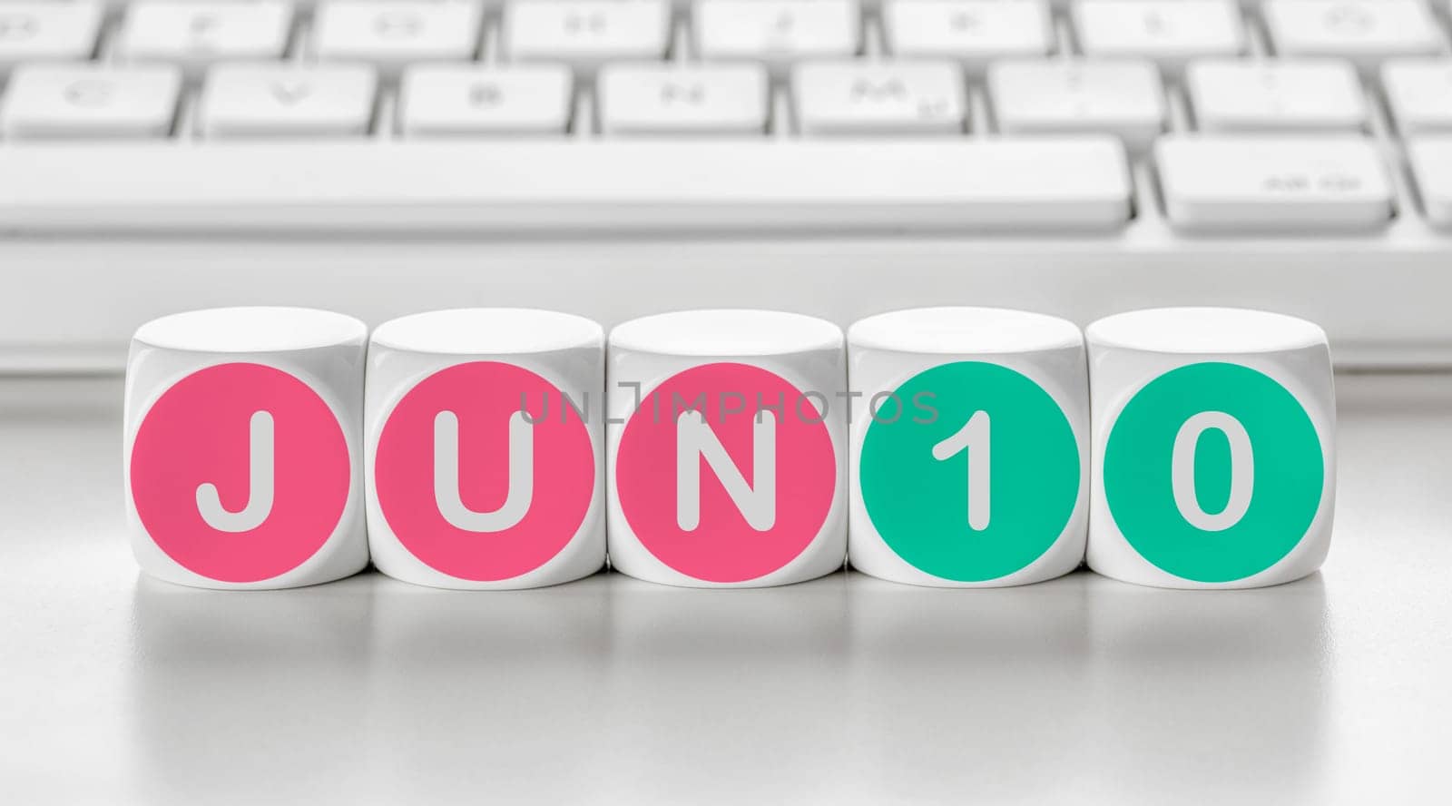 Letter dice in front of a keyboard - June 10