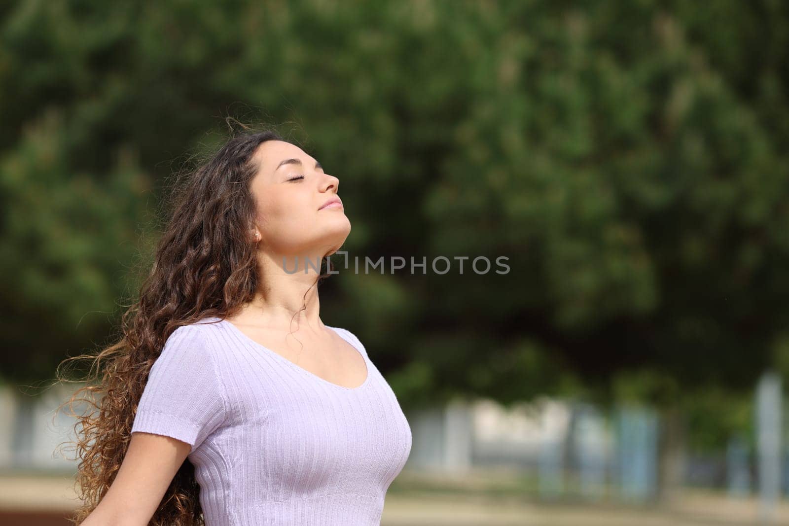 Relaxed woman breathing fresh air in a park