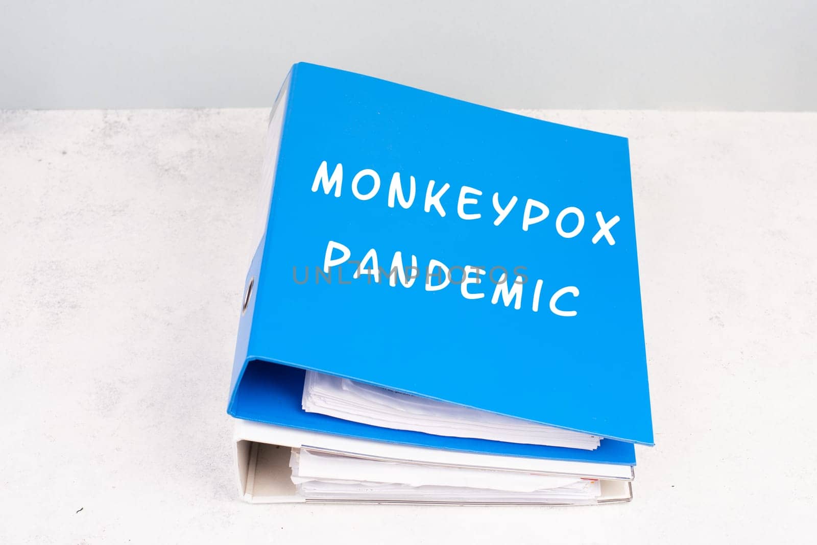 The words monkeypox pandemic are standing in german language on a folder, outbreak of the MPXV virus, infectious disease spreading