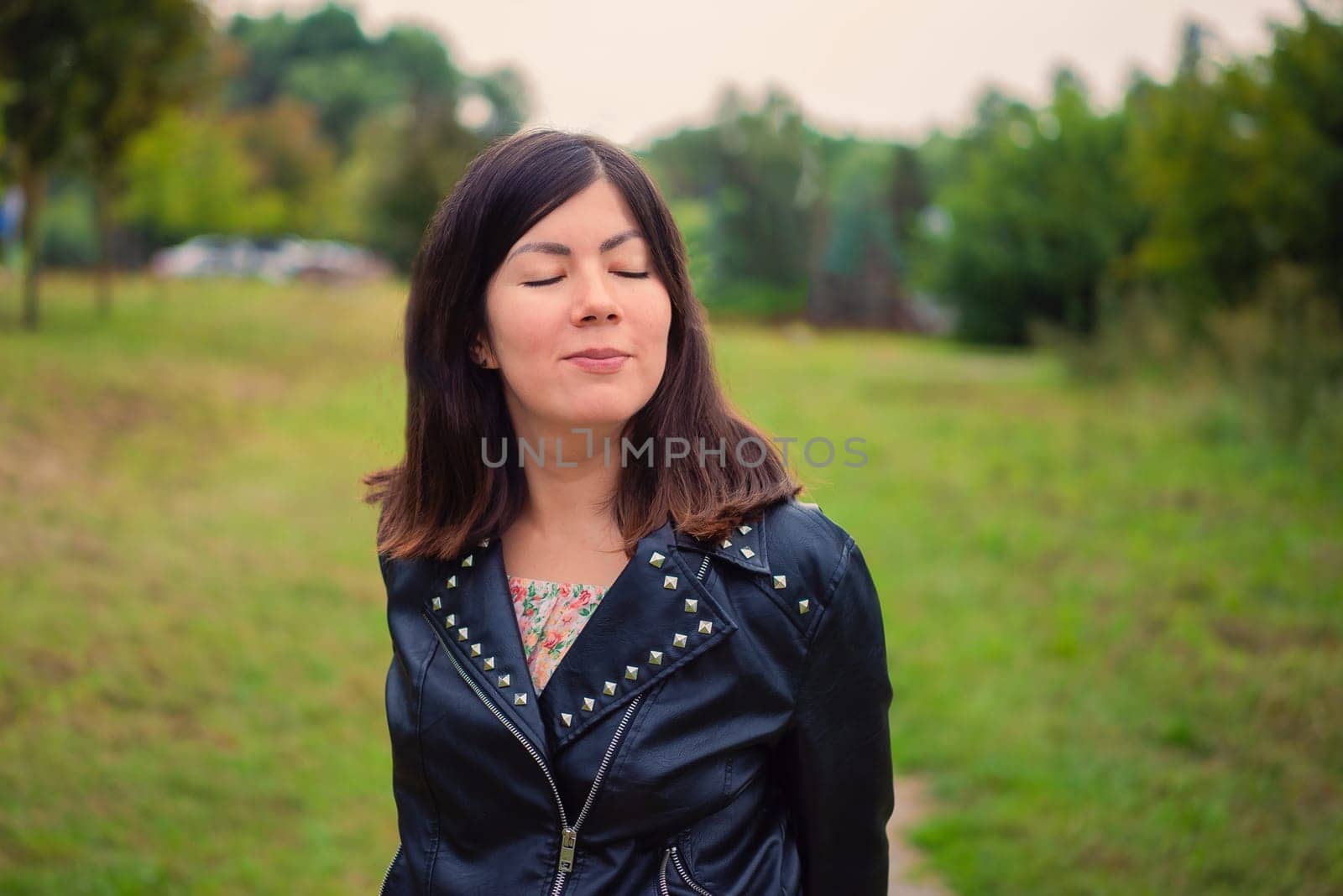 Close portrait of a cute young black-haired girl with closed eyes