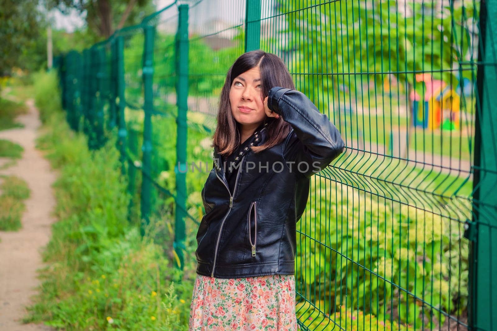 Young dark-haired girl straightens her hair with her hand