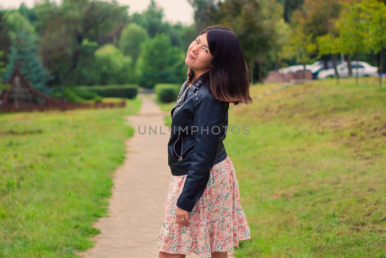 young pretty brunette woman with beautiful long hair in the park