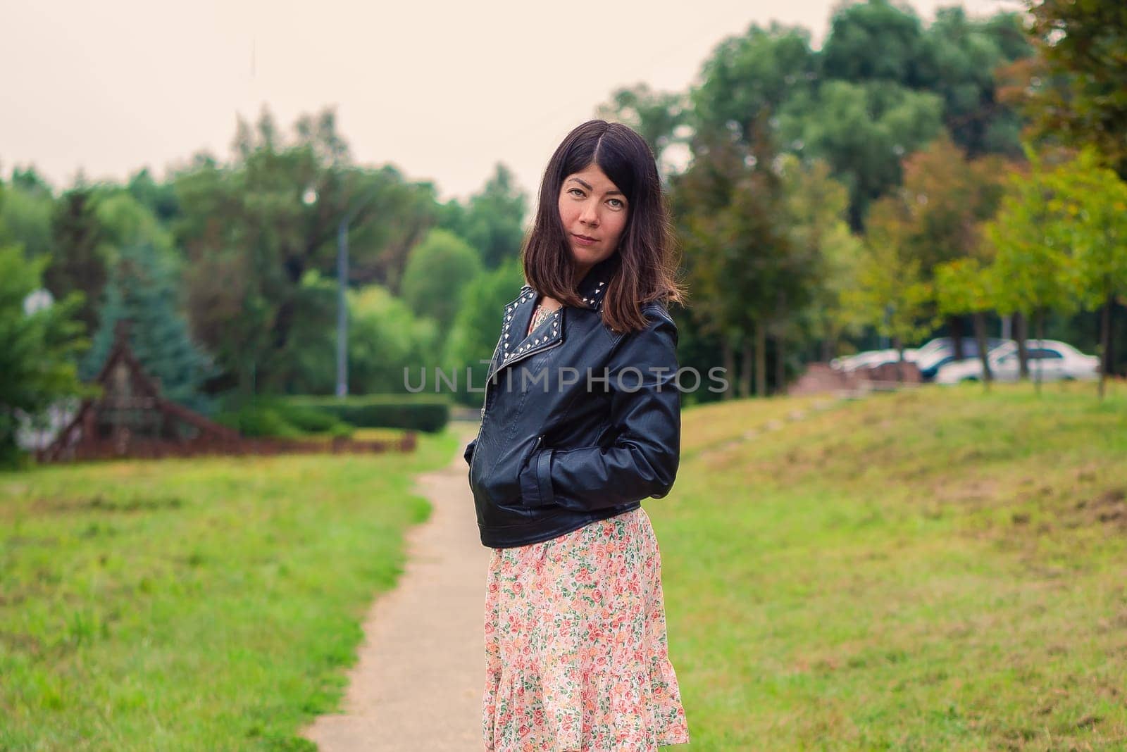 beautiful white brunette woman walking alone in green park