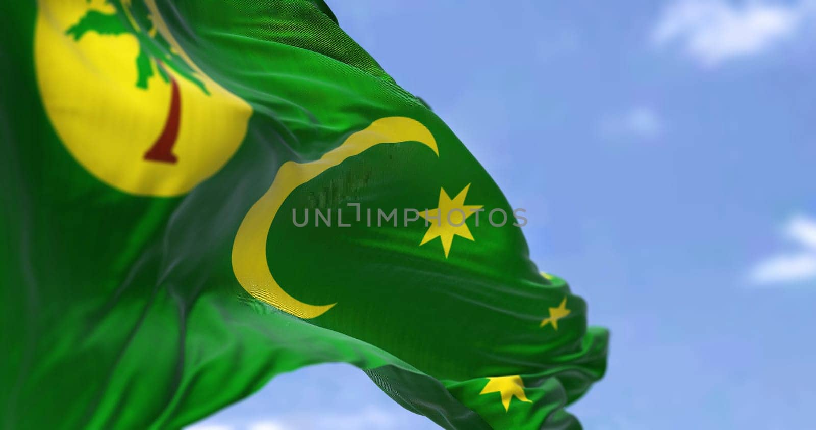 The flag of Cocos (Keeling) Islands waving in the wind on a clear day. Cocos (Keeling) Islands are an Australian external territory in the Indian Ocean
