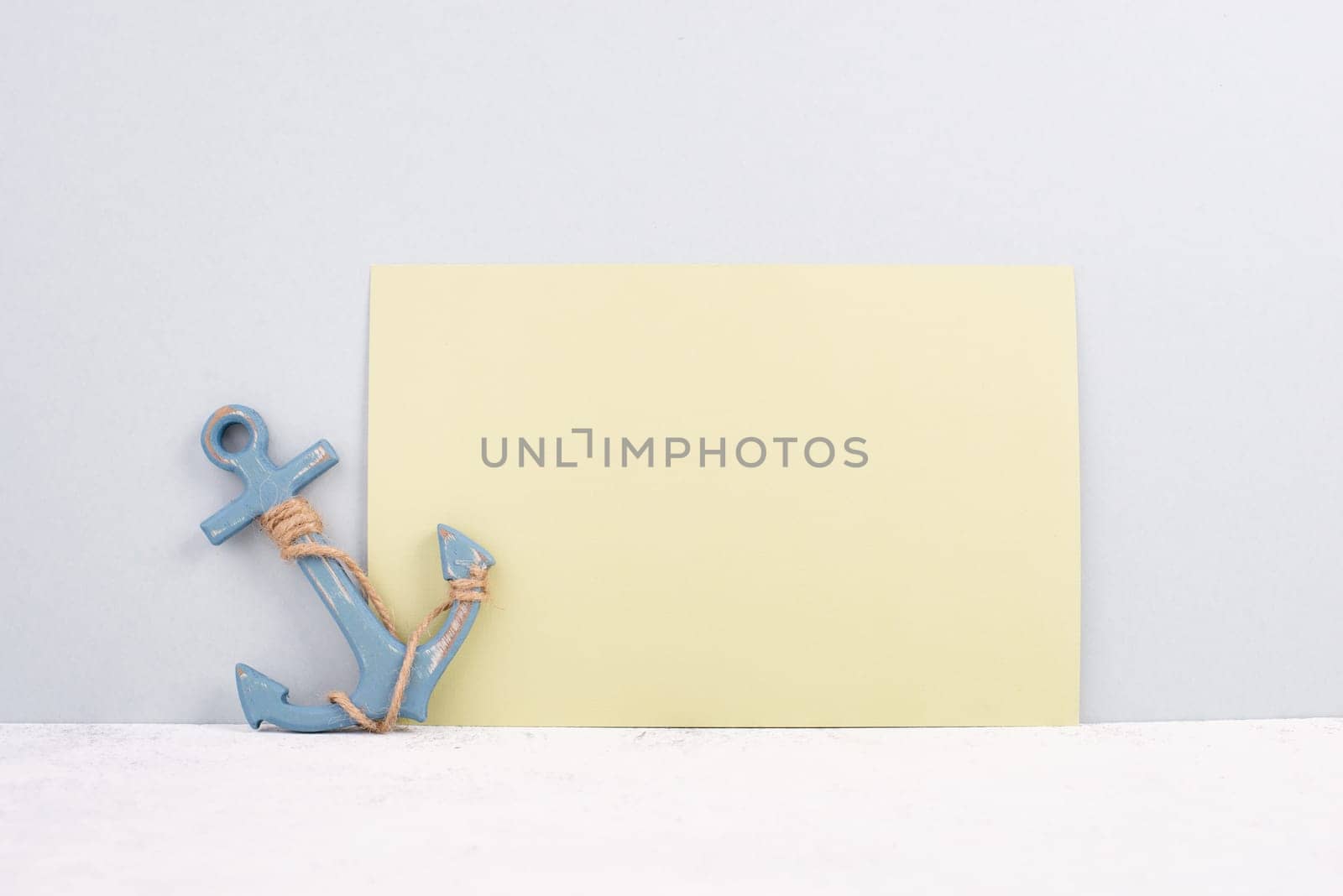 Blue anchor on a yellow background, maritime sea life, sailing trip, summer vacation, tourism concept, copy space for text