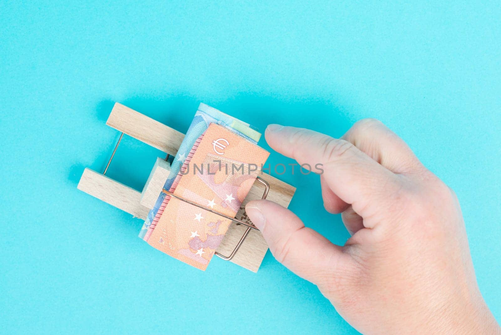 Euro banknotes in a mousetrap, bank loan, finanicial debt, inflation, risky credit and investment, someone wants to take the money, greed