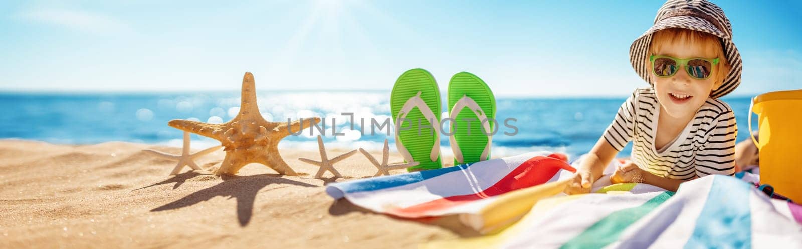 Cute boy on the seacoast in summertime. Concept of the vacation and tourism.