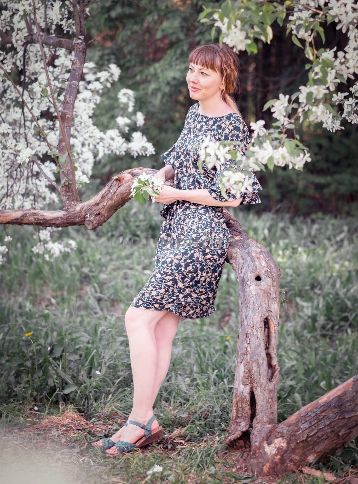Young woman portrait on blooming apple trees background