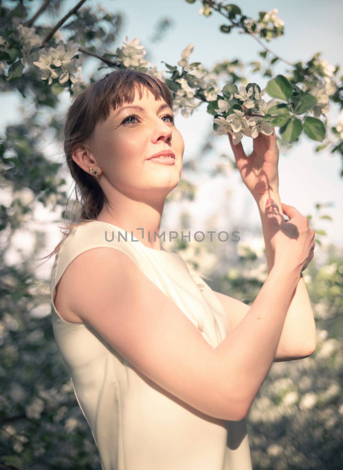 Young woman portrait on blooming apple trees background