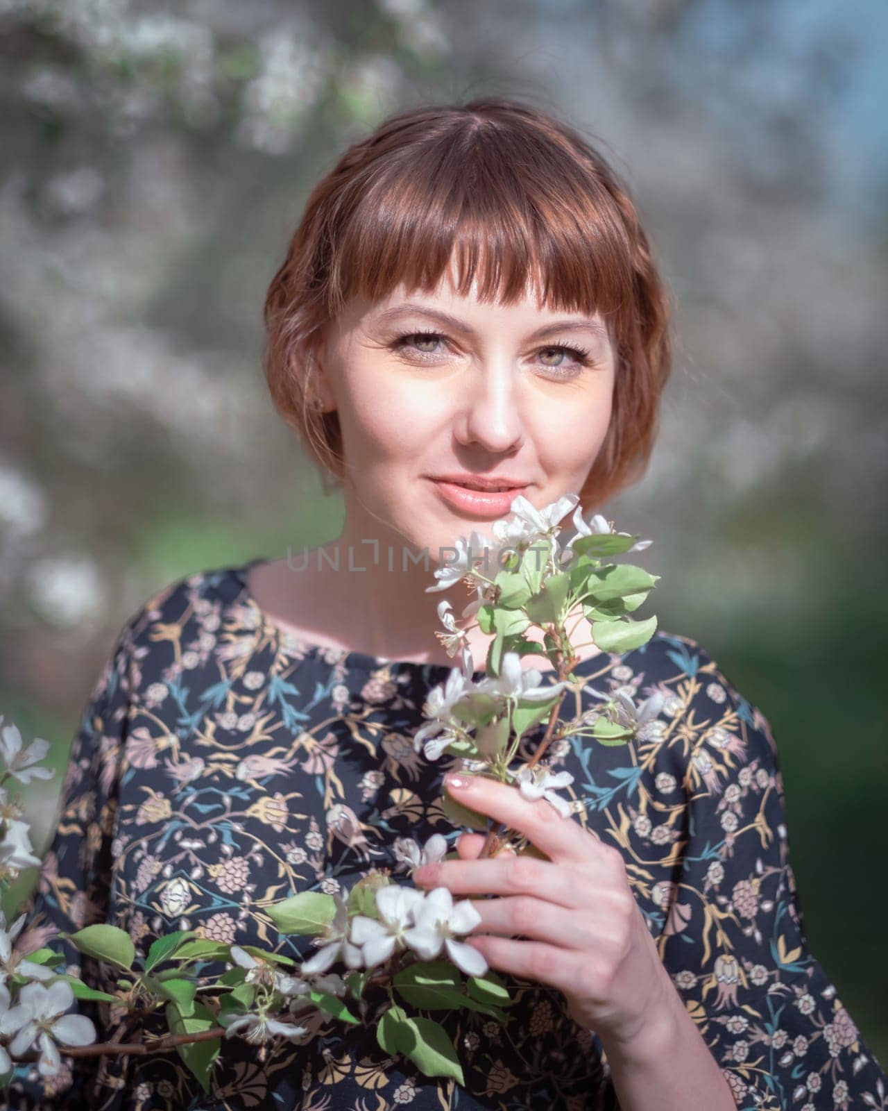 Young woman portrait on blooming apple trees background
