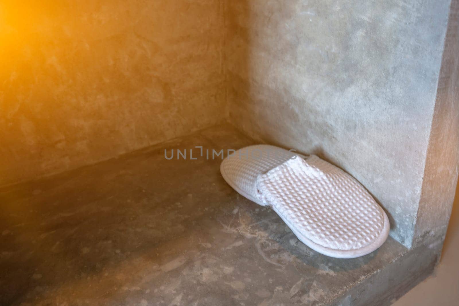 Slippers placed beside the concrete wall house