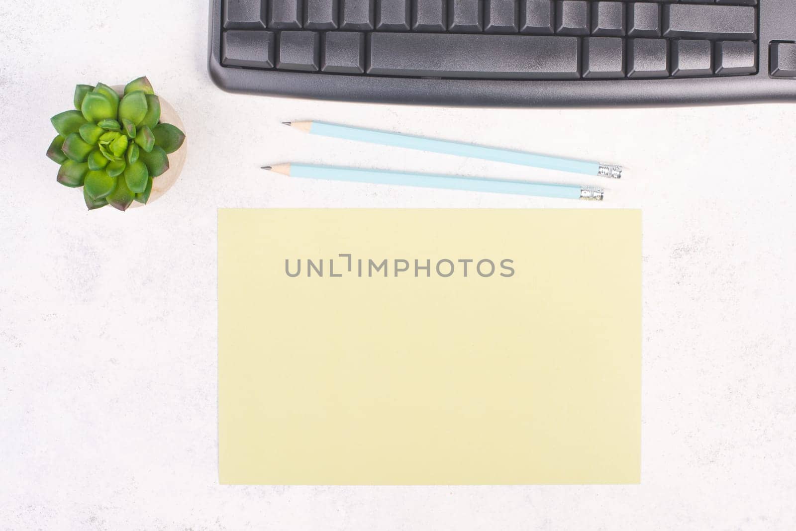Empty paper with a pen, computer keyboard and a cactus, textured background, brainstorming for new ideas, writing a message, taking a break, home office desk