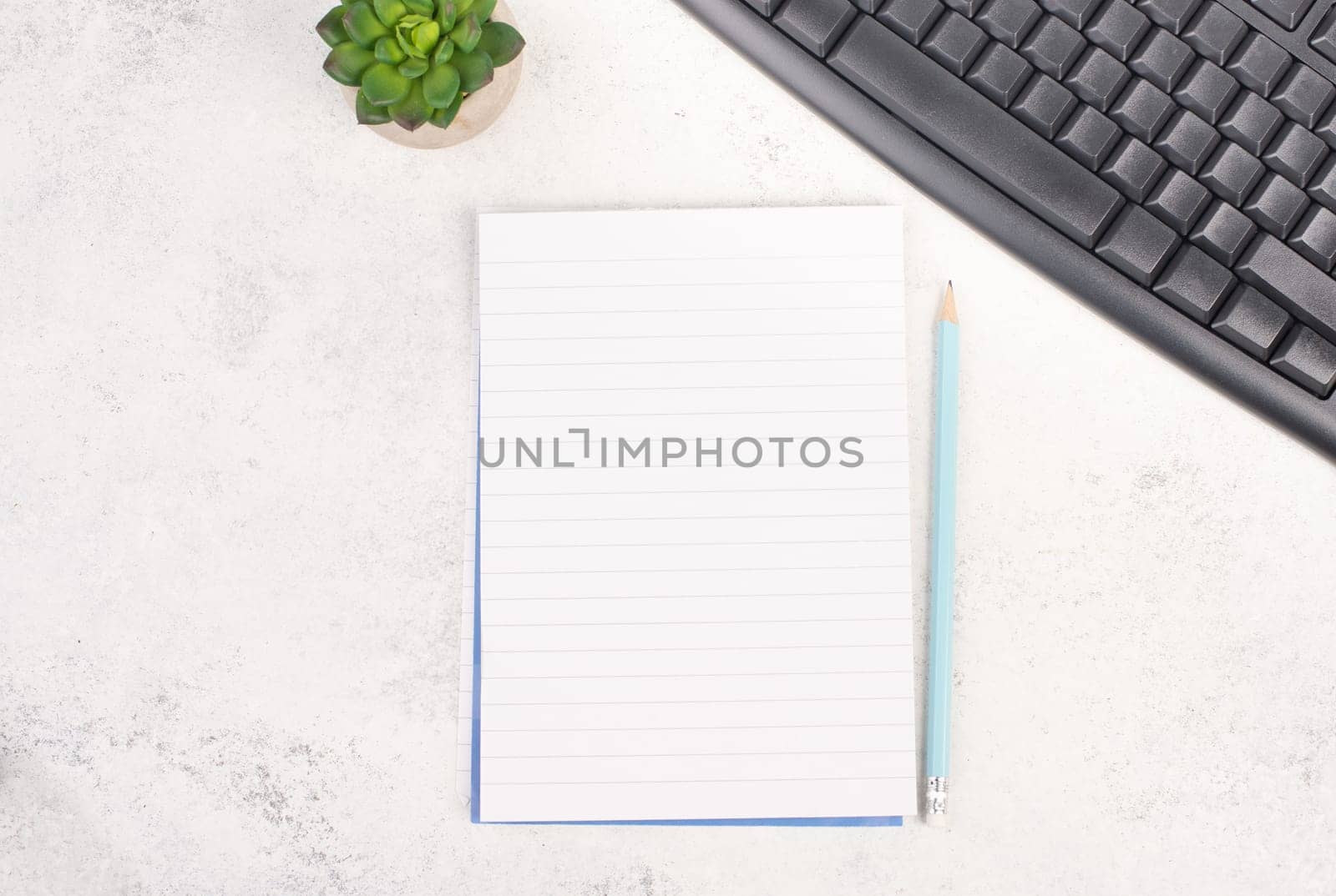 Empty paper with a pen, computer keyboard and a cactus, textured background, brainstorming for new ideas, writing a message, taking a break, home office desk