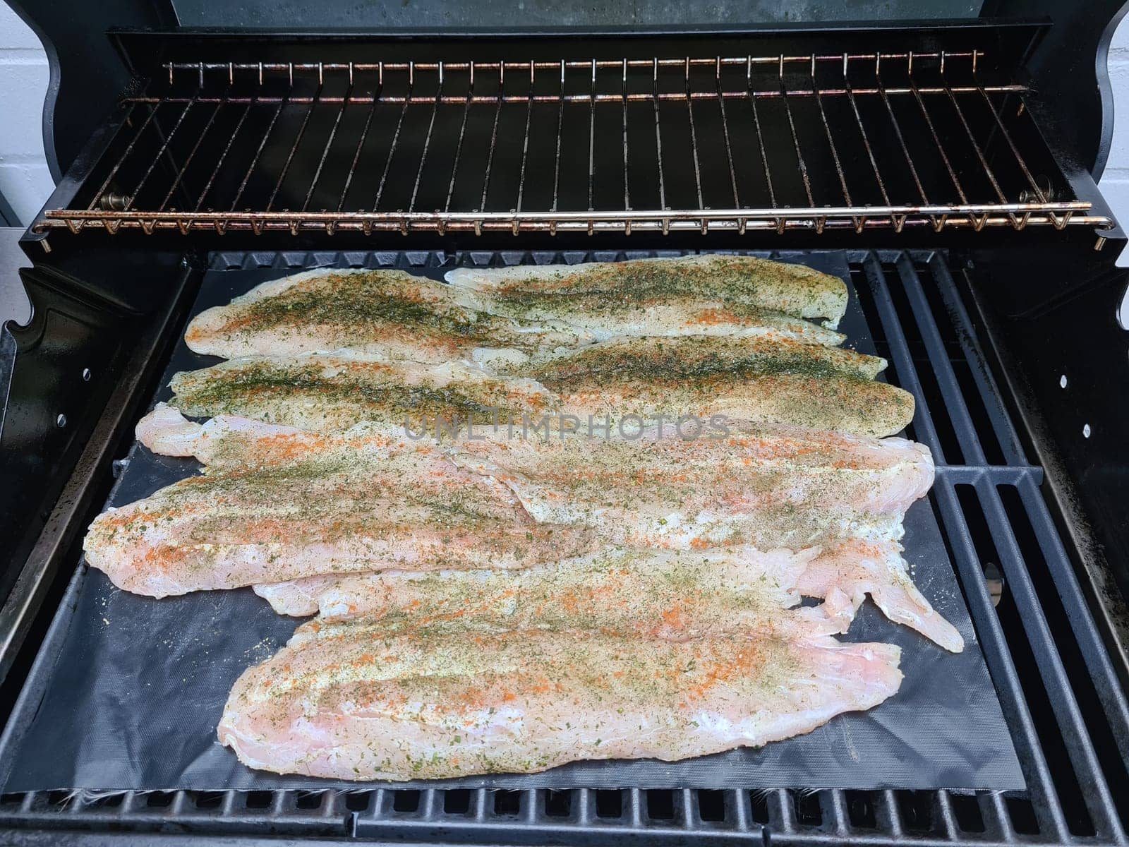 Professional chef cooking fish on a barbeque